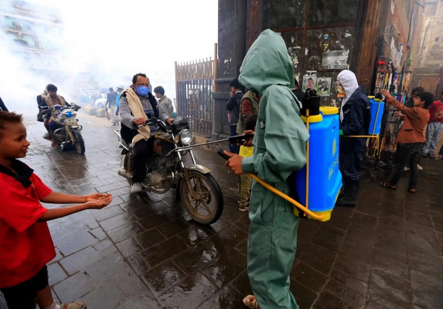 A municipal worker sprays disinfectant as a measure against the coronavirus in the old city market in Sanaa on April 30. (AFP)