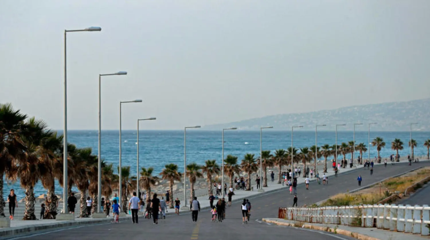 مواطنون يتنزهون أو يمارسون تمارين رياضية على كورنيش الضبية الخالي من السيارات في شمال بيروت أول من أمس (أ.ف.ب)