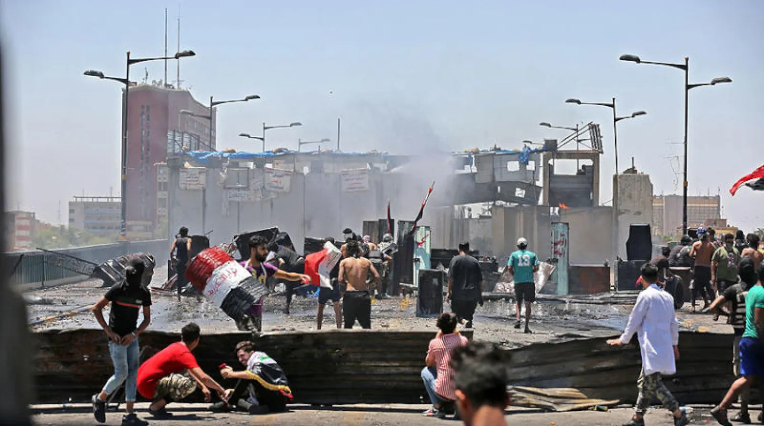 مواجهات بين قوات الأمن ومتظاهرين ضد الحكومة العراقية الجديدة على جسر «الجمهورية» في بغداد أمس (أ.ف.ب)