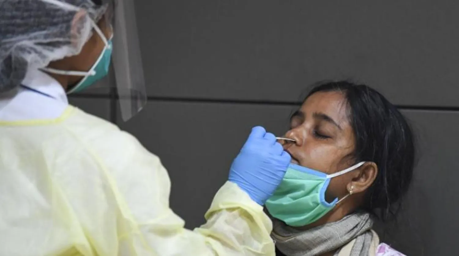 Hindistanlı bir kız çocuğuna Dubai Uluslararası Havaalanı'nda test yapılıyor (AFP)
