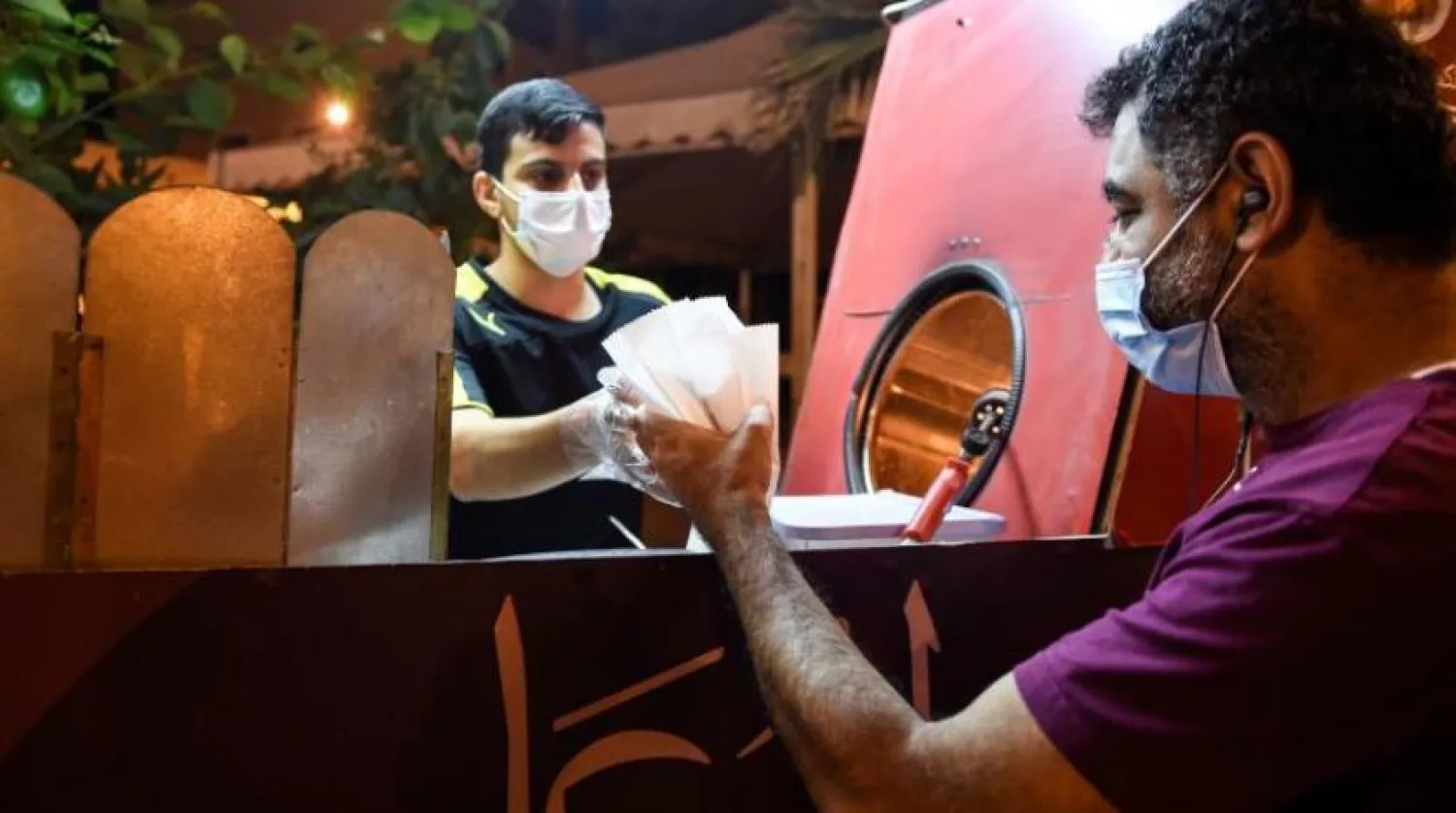 Manama’da koruyucu maske ile ayçekirdeği satan bir esnaf (AFP)