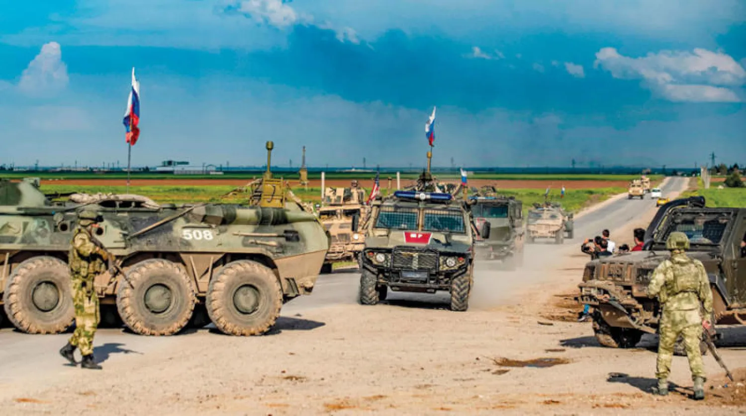 دورية عسكرية روسية تمر قرب عربة أميركية شمال شرقي سوريا (أ.ف.ب)