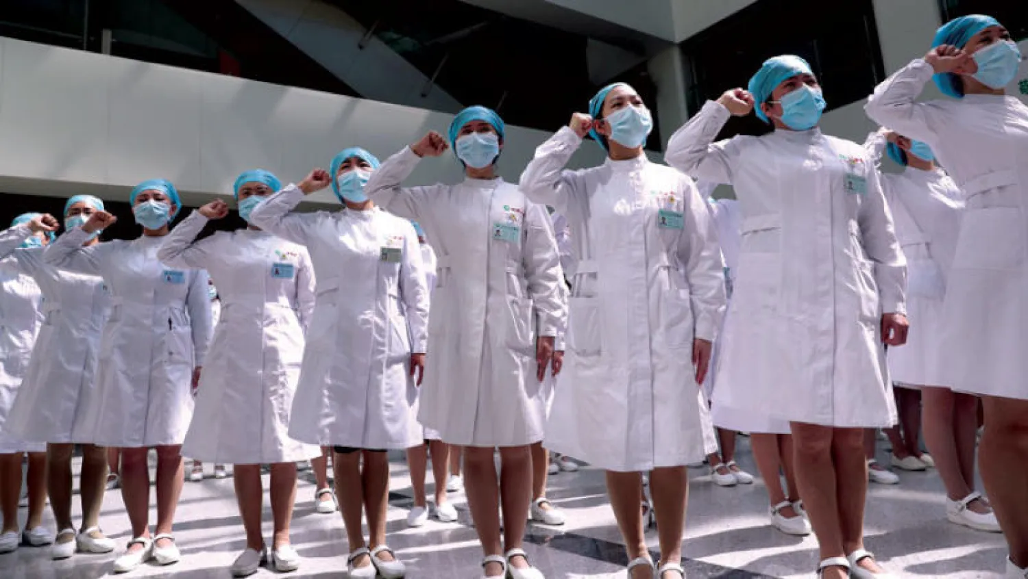 فعالية بمناسبة اليوم العالمي للممرضات والممرضين أمام مستشفى «تونغي» في مدينة ووهان الصينية منشأ فيروس «كورونا» أمس (رويترز)