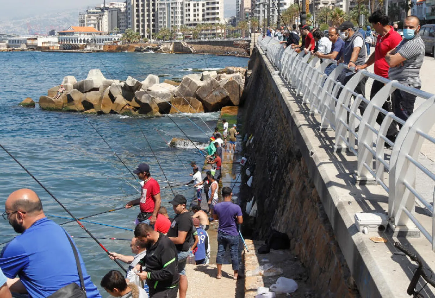 لبنانيون يصطادون السمك عند الواجهة البحرية لبيروت (رويترز)