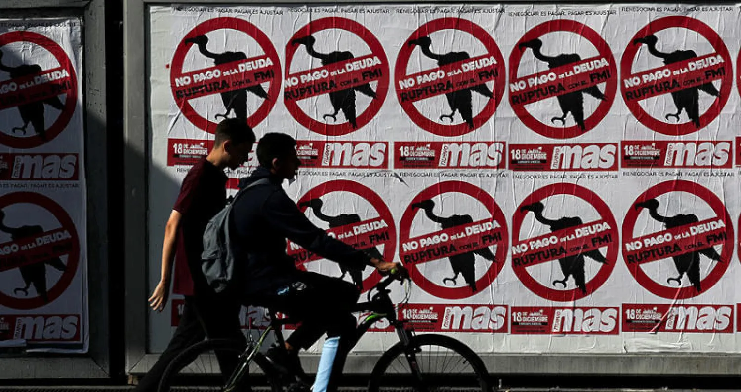 ملصقات في العاصمة الأرجنتينية بوينس آيريس تطالب بالتوقف عن سداد ديون البلاد (رويترز)