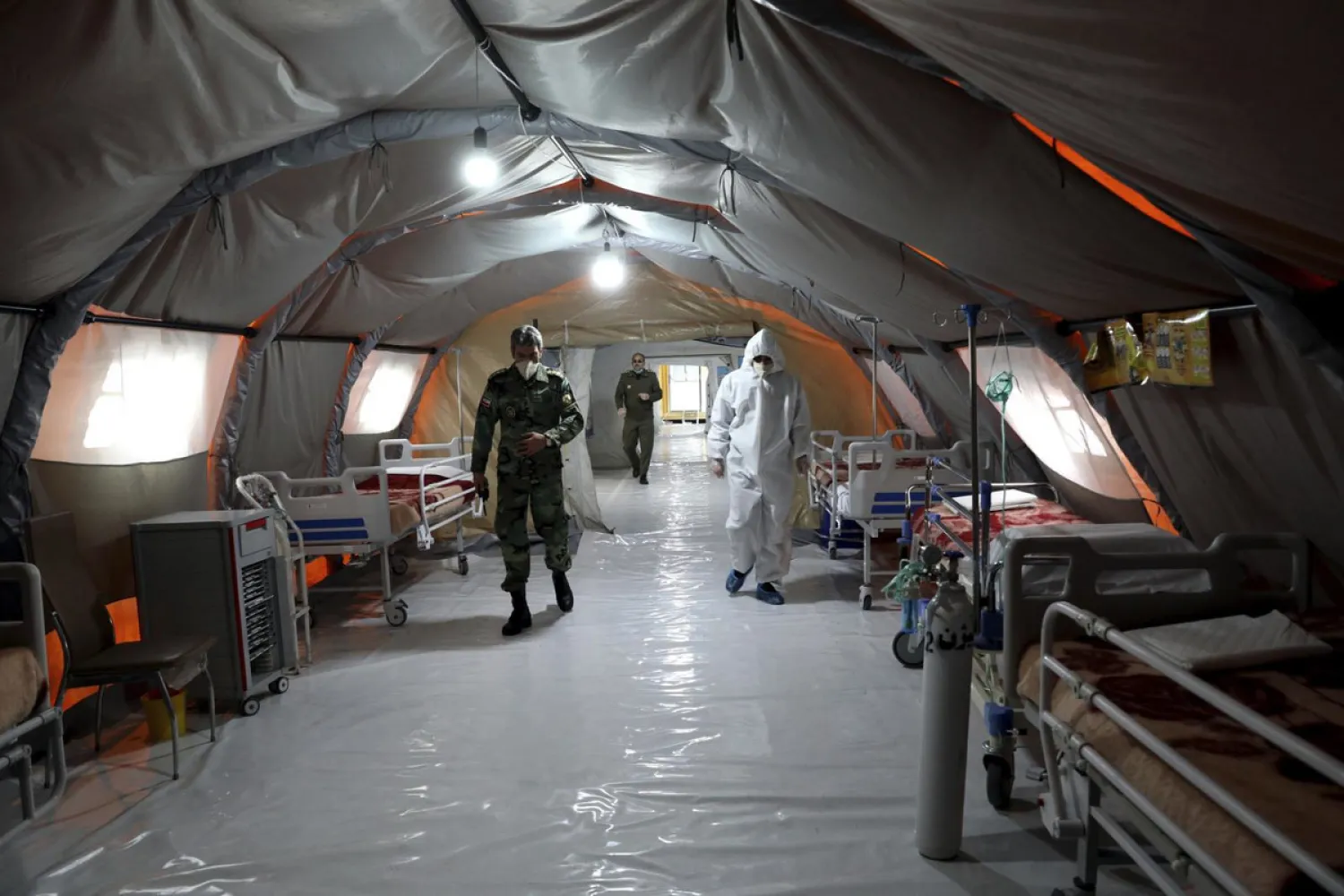 In this March 26, 2020 file photo, Iranian army soldiers work in a temporary 2,000-bed hospital for coronavirus patients set up by the army at the International Exhibition Center in northern Tehran, Iran. Dozens of medical staffers have died of COVID-19 in Iran. Doctors and nurses and other staffers have been hard hit. During the first 90 days of the virus outbreak alone, about one medical staffer died each day. (AP Photo/Ebrahim Noroozi, File)