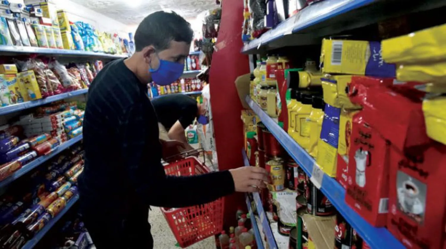 Cezayirli bir vatandaş güvenlik önlemleri altında Ramazan alışverişini yapıyor (AFP)