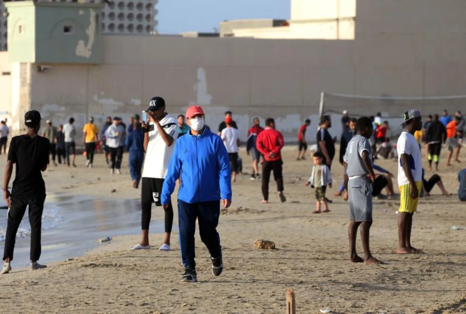 ليبيون على الشاطئ في طرابلس قبل الإفطار بالرغم من الإغلاق المفروض لمواجهة فيروس كورونا (أ.ف.ب)