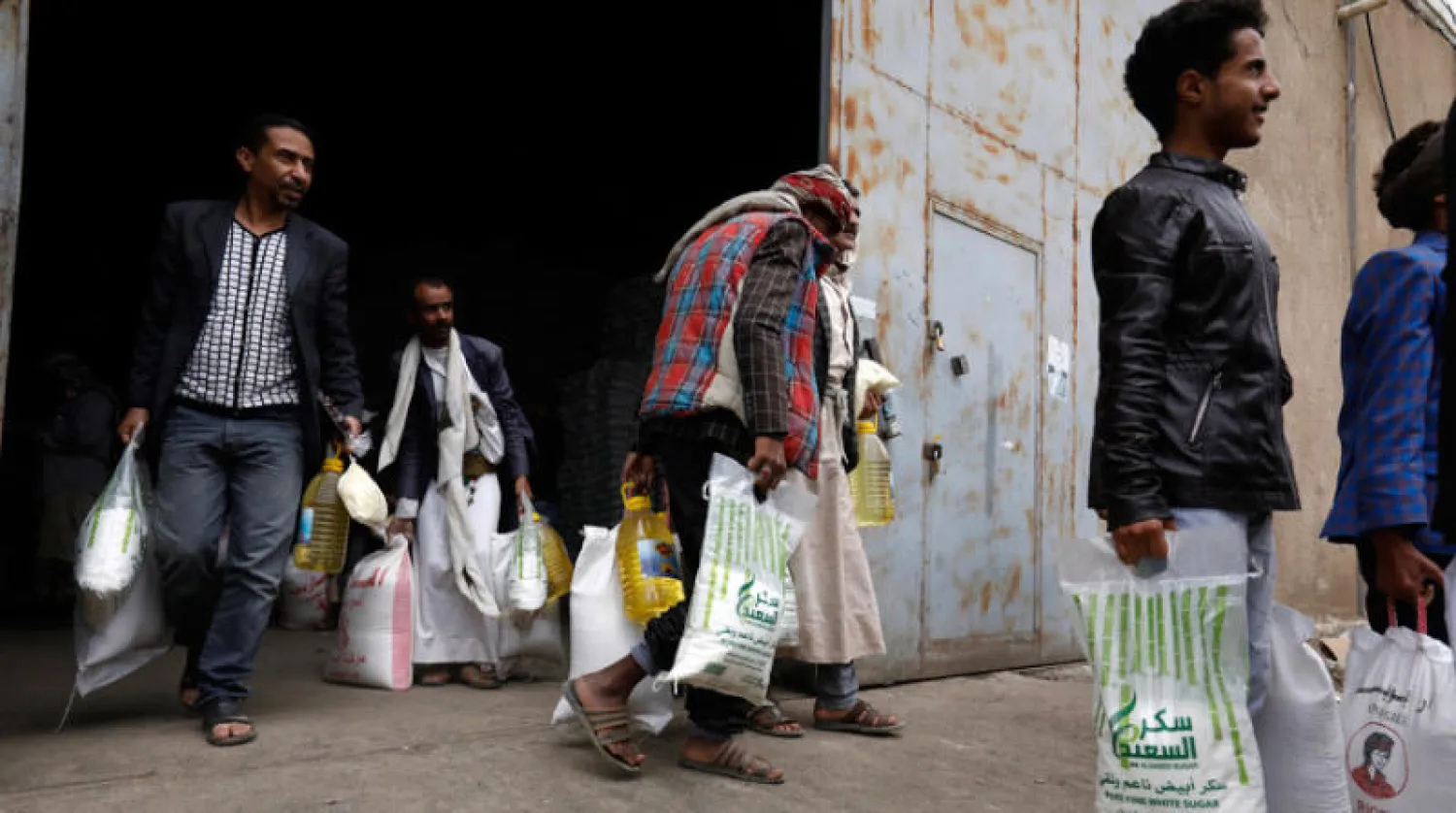 يمنيون يتلقون مساعدات غذائية في صنعاء (إ.ب.أ)