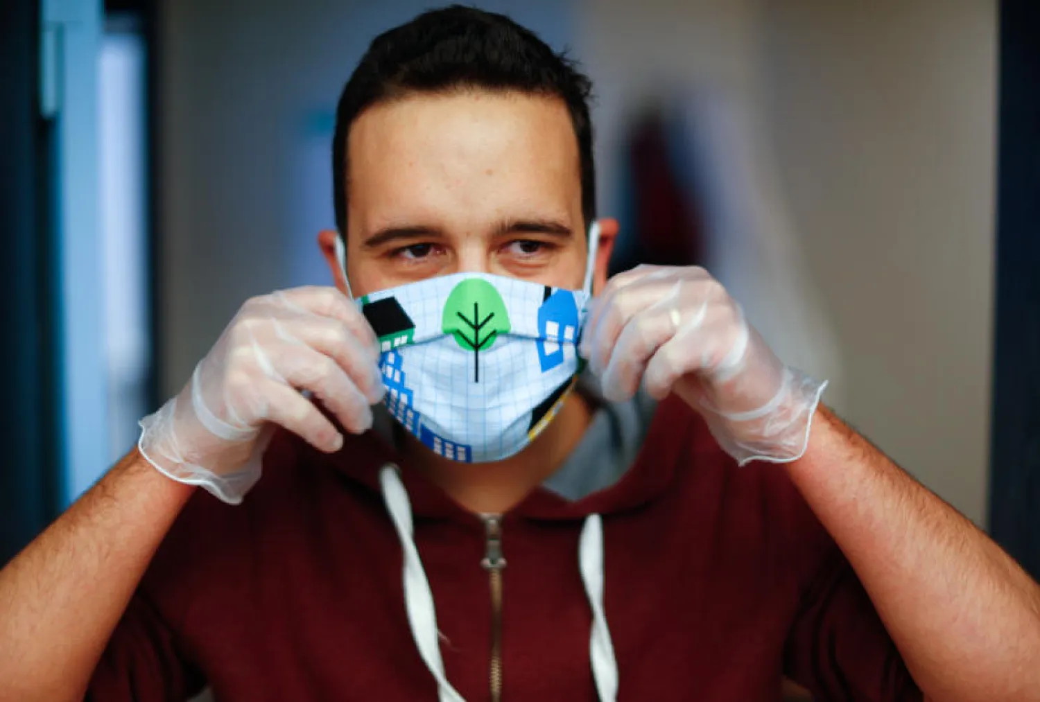 مدرس يشرح للتلاميذ كيفية ارتداء قناع الوجه الواقي (رويترز)