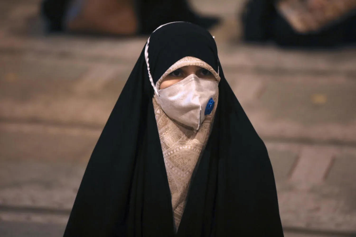 إيرانية تضع كمامة خلال حضورها صلاة ليلة القدر في مسجد جامعة طهران (أ.ب)