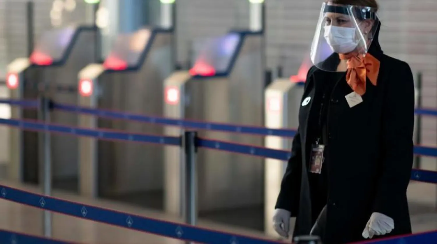 Fransız Charles de Gaulle Havalimanı'nda maske takan bir görevli (AFP) 
