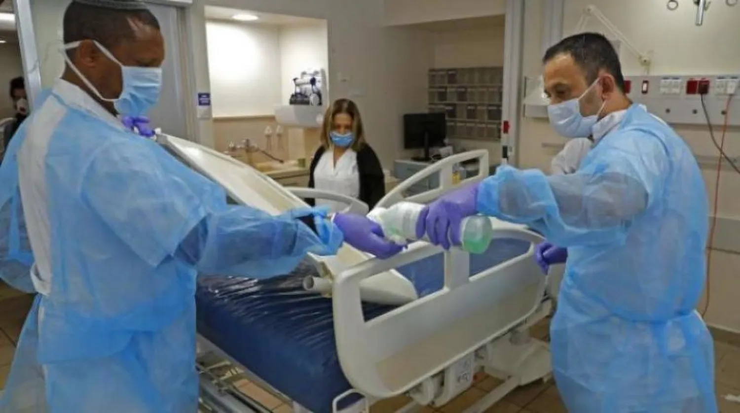 Bir sağlık ekibi, koronavirüs hastalarının tedavi olacağı bir odayı dezenfekte ediyor (AFP)