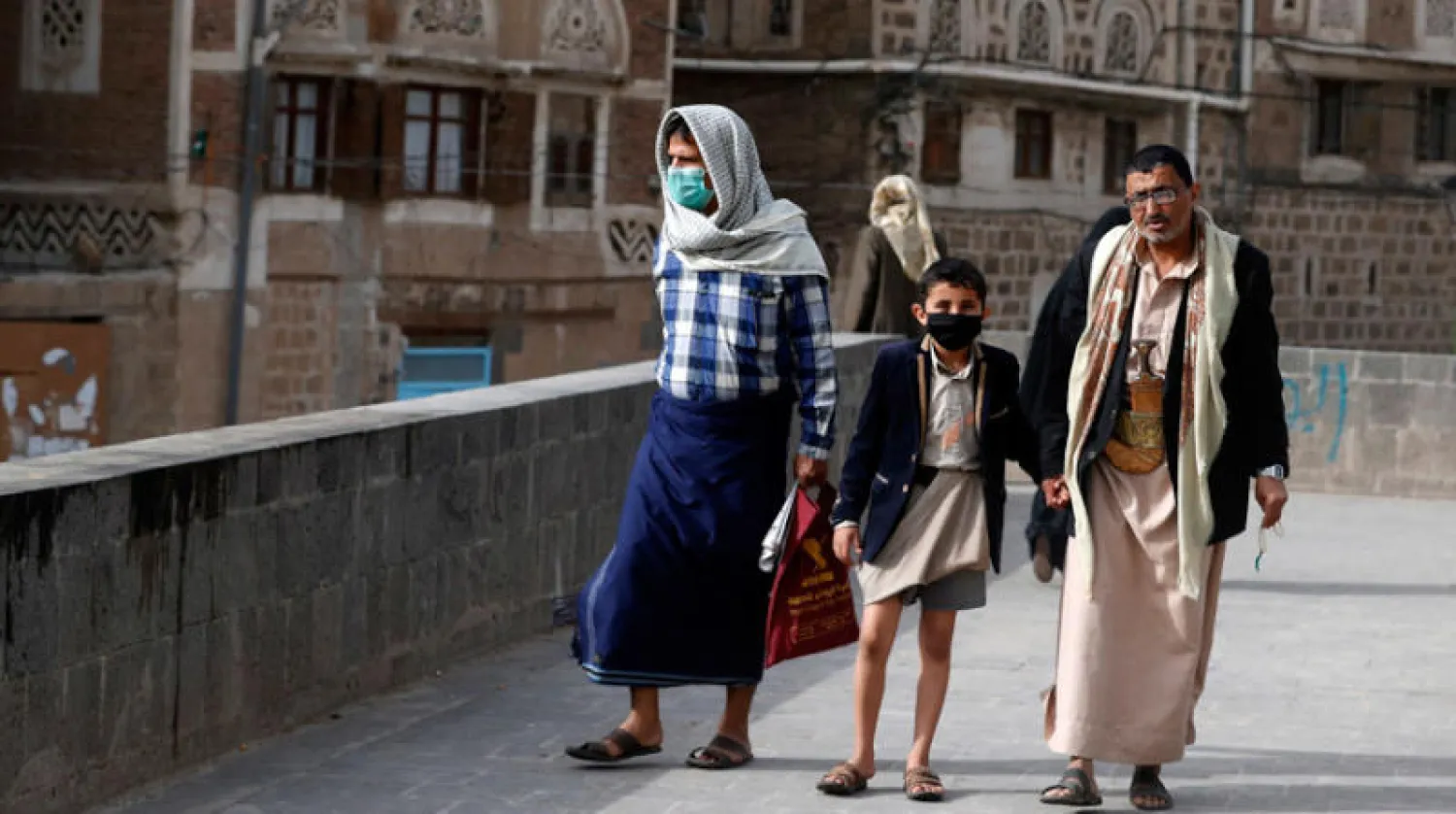 يمنيون يسيرون وسط صنعاء القديمة (إ.ب.أ)