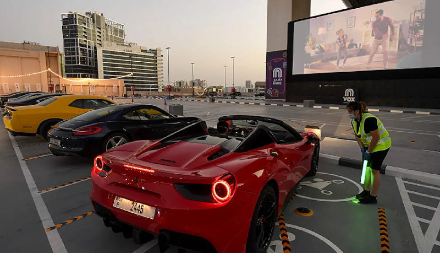 موظفة تدقق تذاكر الجمهور خلال عرض سينمائي في الهواء الطلق خارج «مول الإمارات» في دبي مساء أمس (أ.ف.ب)