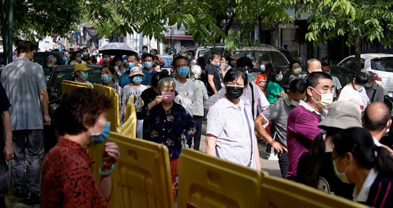 مقيمون في ووهان يستعدون للخضوع لفحص «كورونا» أمس (رويترز)