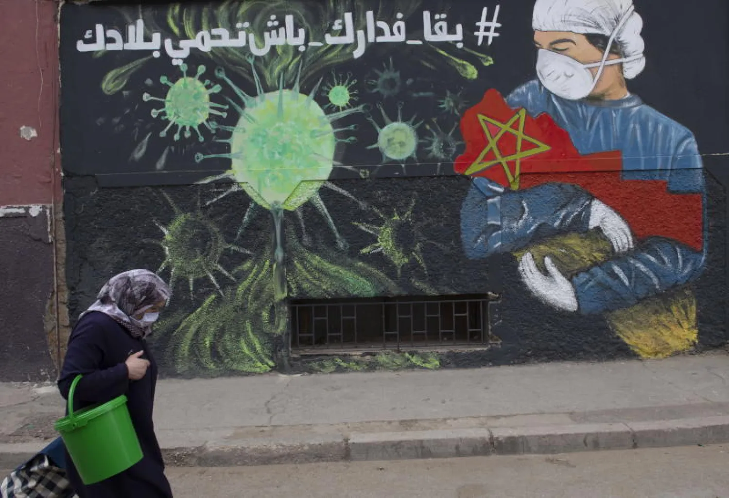 سيدة مغربية تسير في أحد شوارع مدينة سلا (إ.ب.أ)