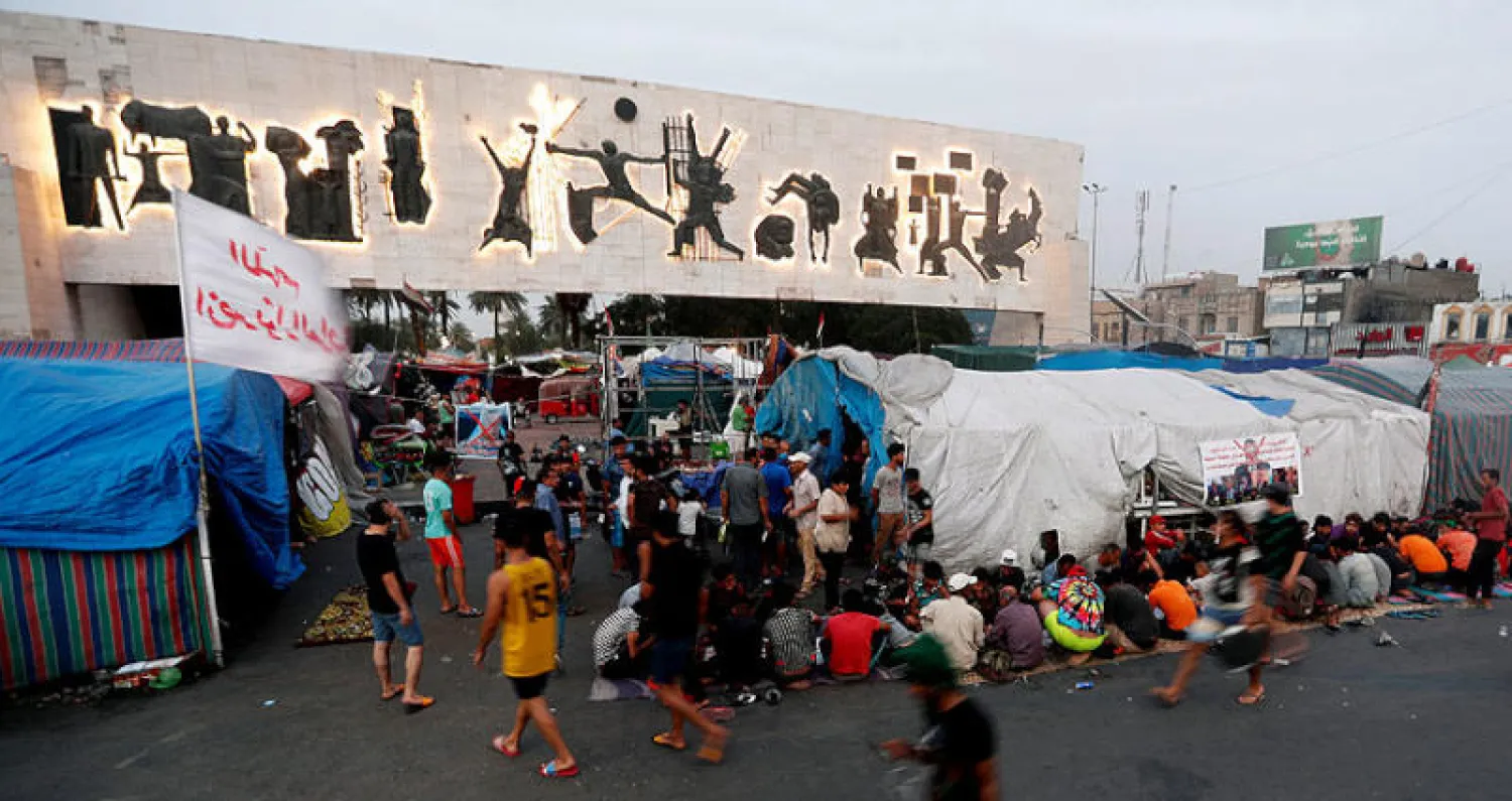 محتجون يتناولون طعام الإفطار في ساحة التحرير ببغداد (رويترز)