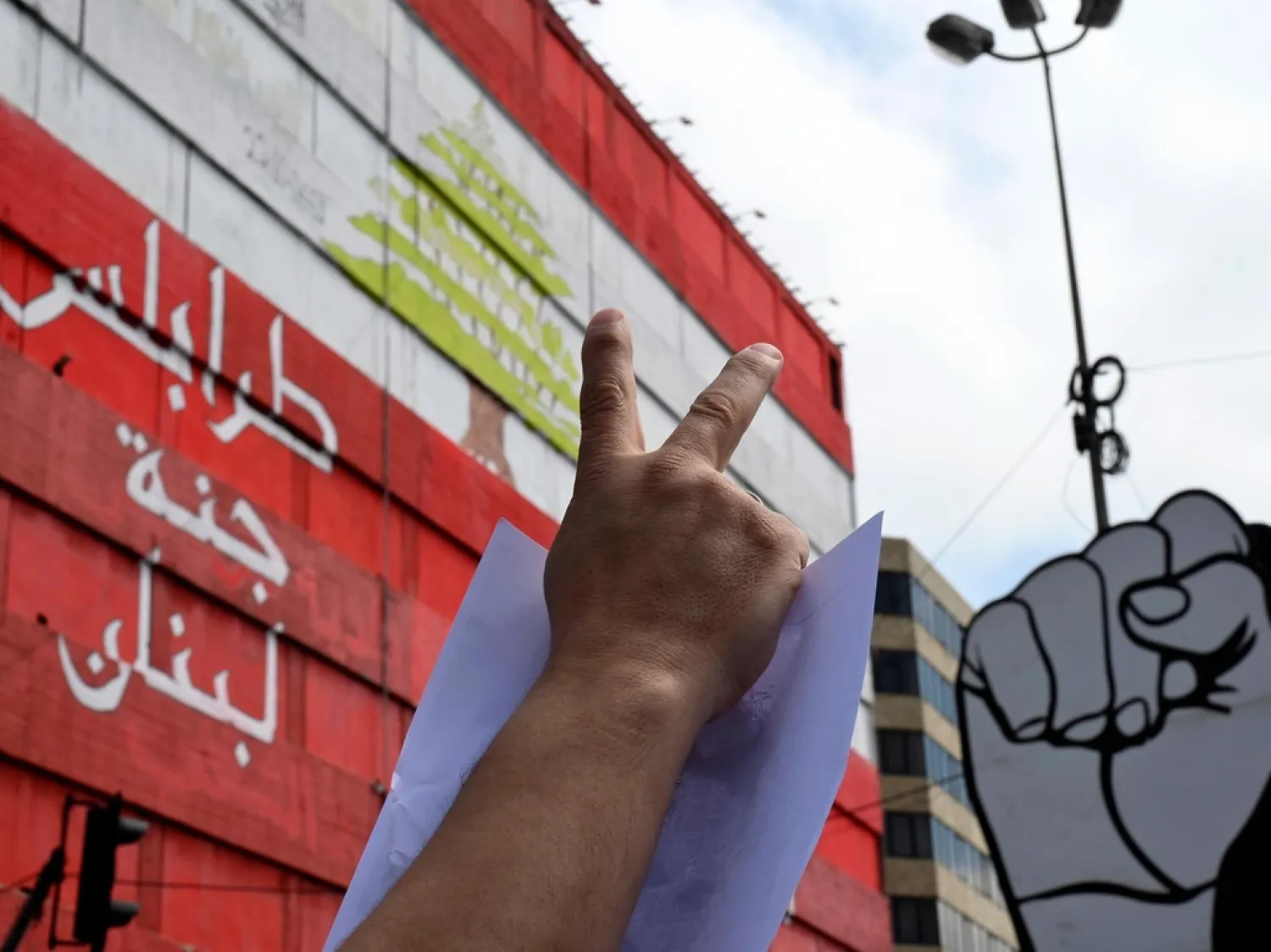 A man flashes the victory sign during a protest at al-Nour Square in Tripoli, Lebanon. (EPA)