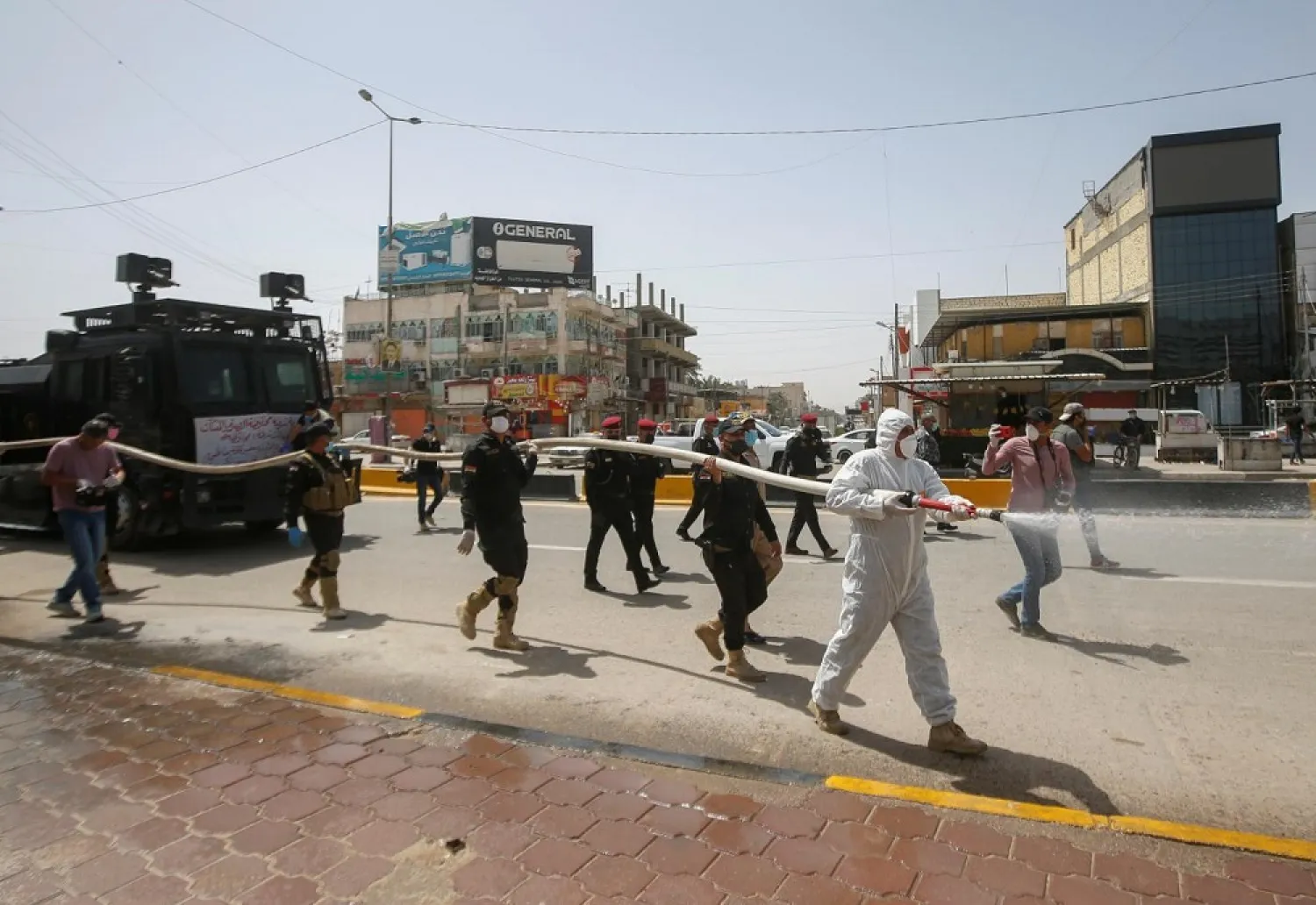 A municipal team sprays the streets to halt the spread of coronavirus in Basra. (Reuters)