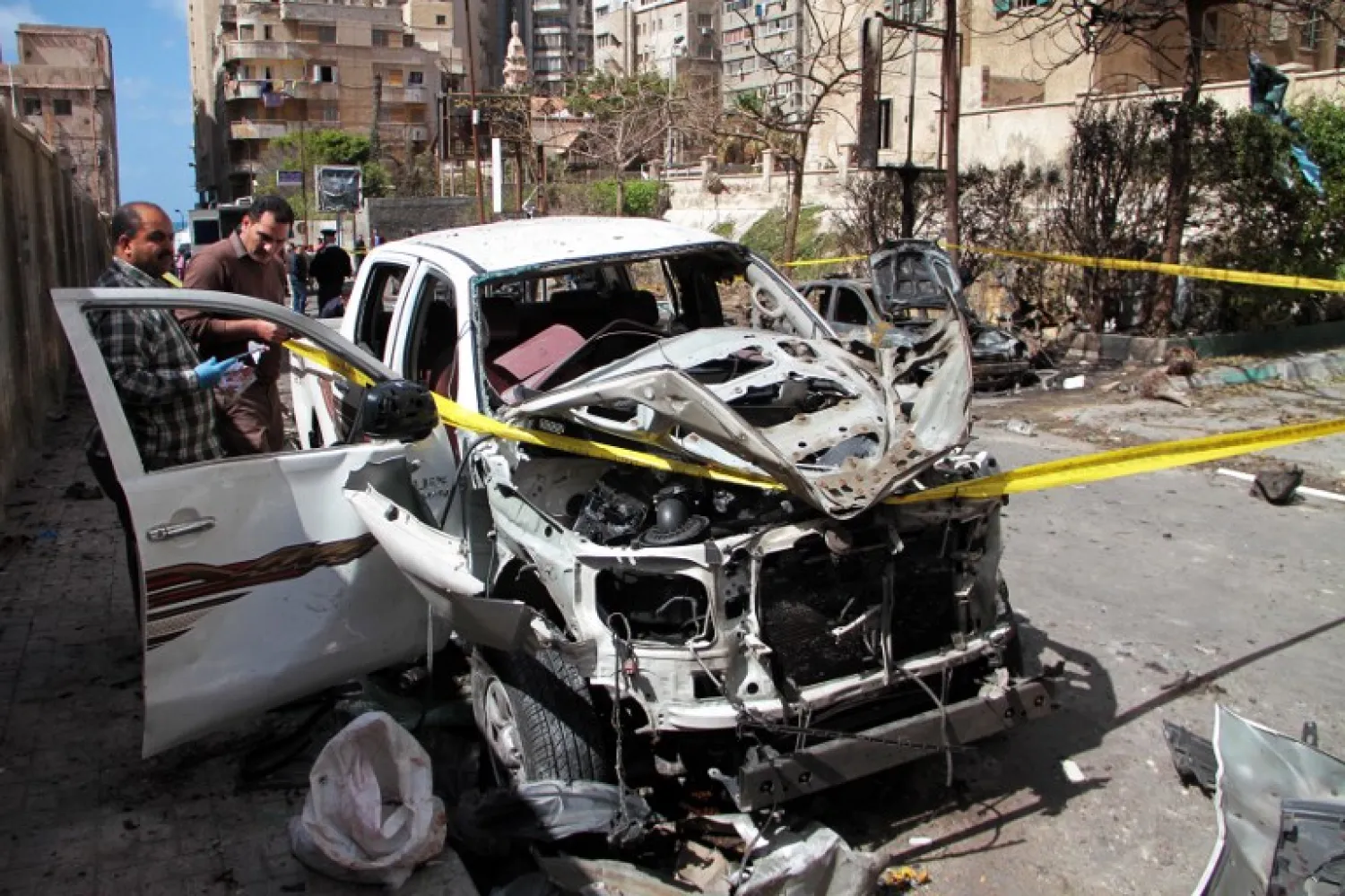 Egyptian forensics check a destroyed vehicle at the site of a bomb attack in the northern port city of Alexandria, which hit a convoy of the city's security chief, on March 24, 2018. (AFP PHOTO)
