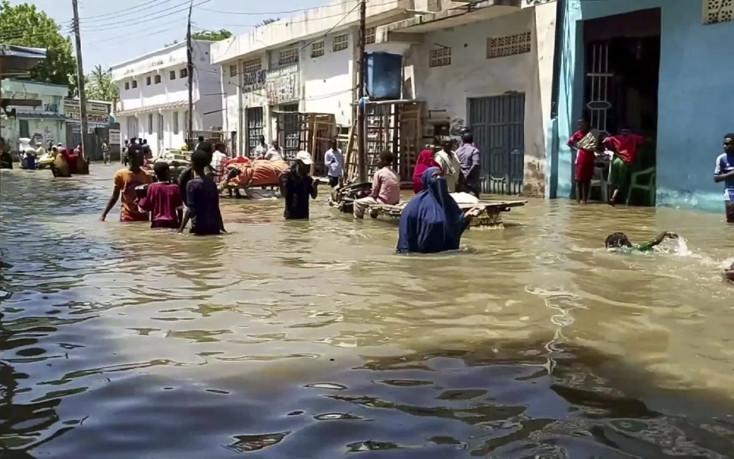 In this image made from video taken Sunday, May 17, 2020, people wade through a flooded street in Beledweyne, central Somalia. (AP)