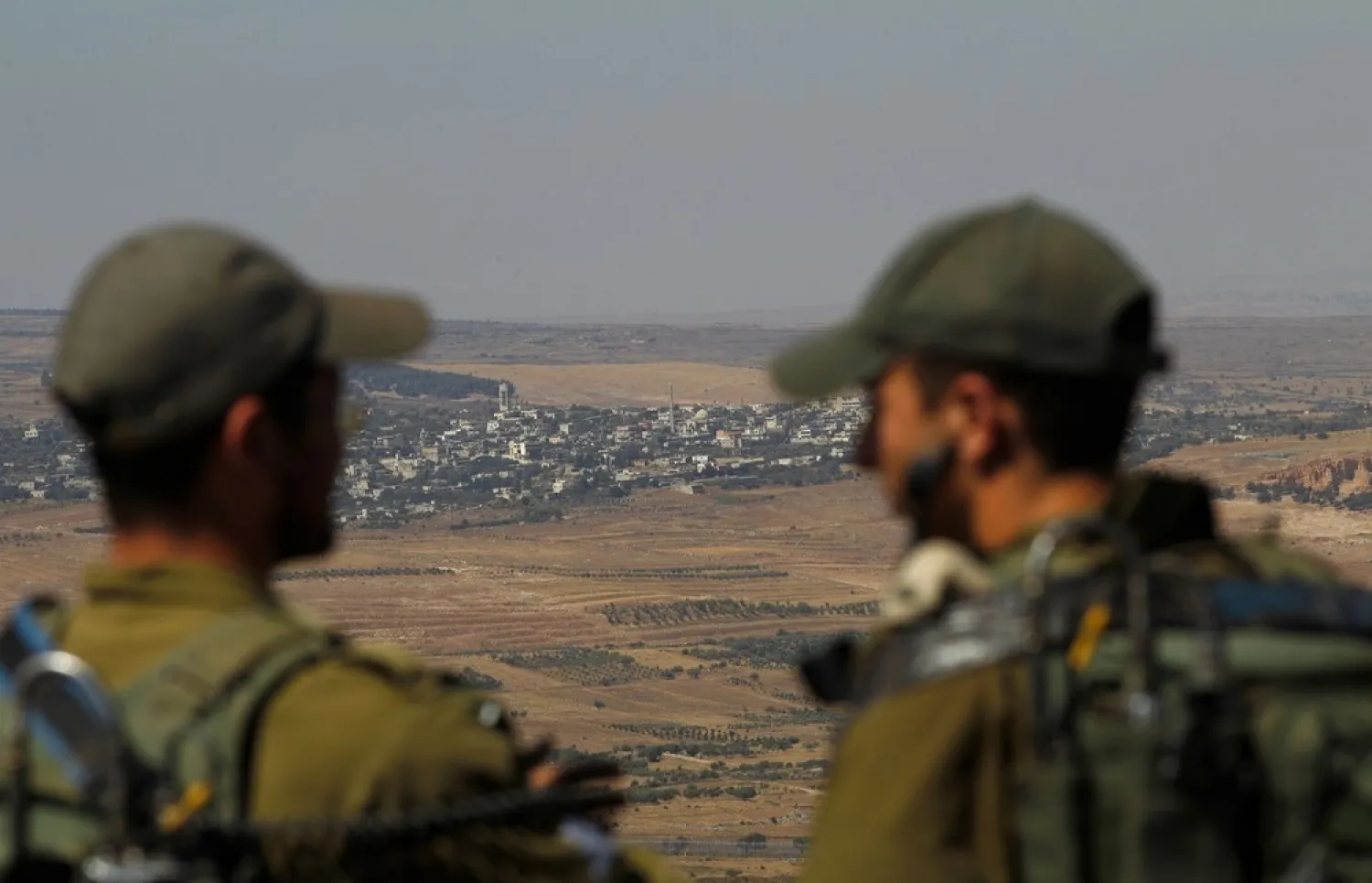 Israeli soldiers at an army base in the Israeli-annexed Syrian Golan Heights look out across the southwestern Syrian province of Quneitra, visible across the border on July 7, 2018. (AFP)