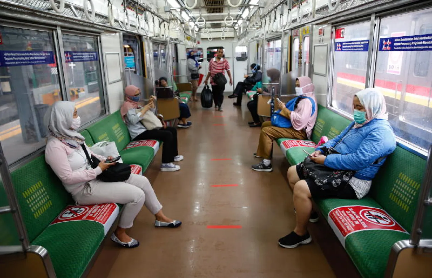 ركاب قطار يطبقون قواعد التباعد الاجتماعي في جاكرتا (إ.ب.أ)