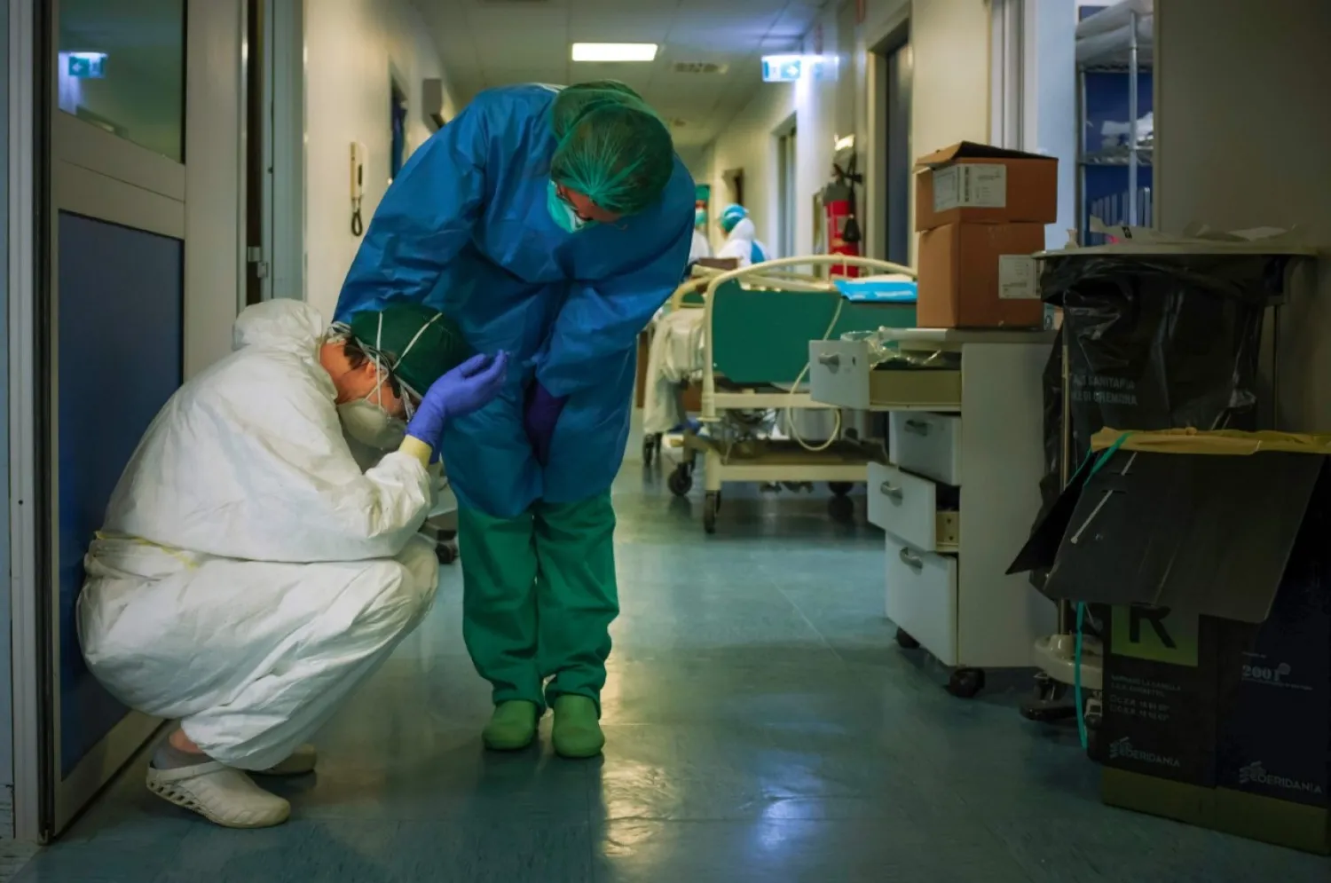 A nurse wearing a protective mask and gear comforts another at the Cremona hospital, southeast of Milan, Lombardy, March 13, 2020. (AFP Photo)