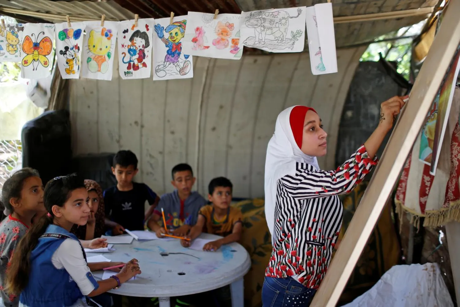Palestinian school girl Fajr Hmaid teaches her neighbors’ children an Arabic language lesson as schools are shut due to the coronavirus restrictions, at her family house in Gaza, May 19, 2020. (Reuters)