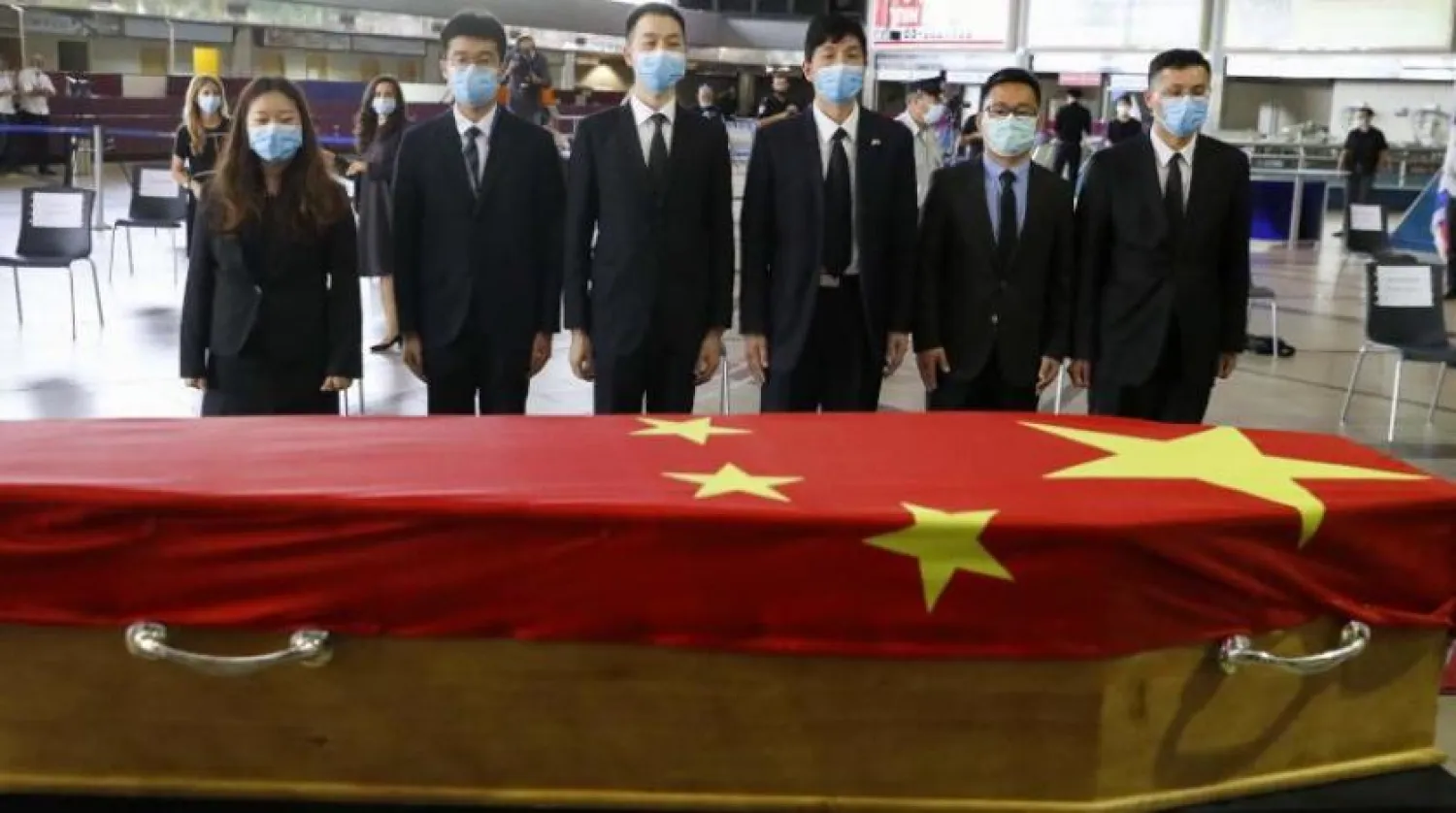 Çinli yetkililer, ülkesine gönderilmeye hazırlanan Çin'in Tel Aviv Büyükelçisi’nin tabutunu selamlıyor (AFP)