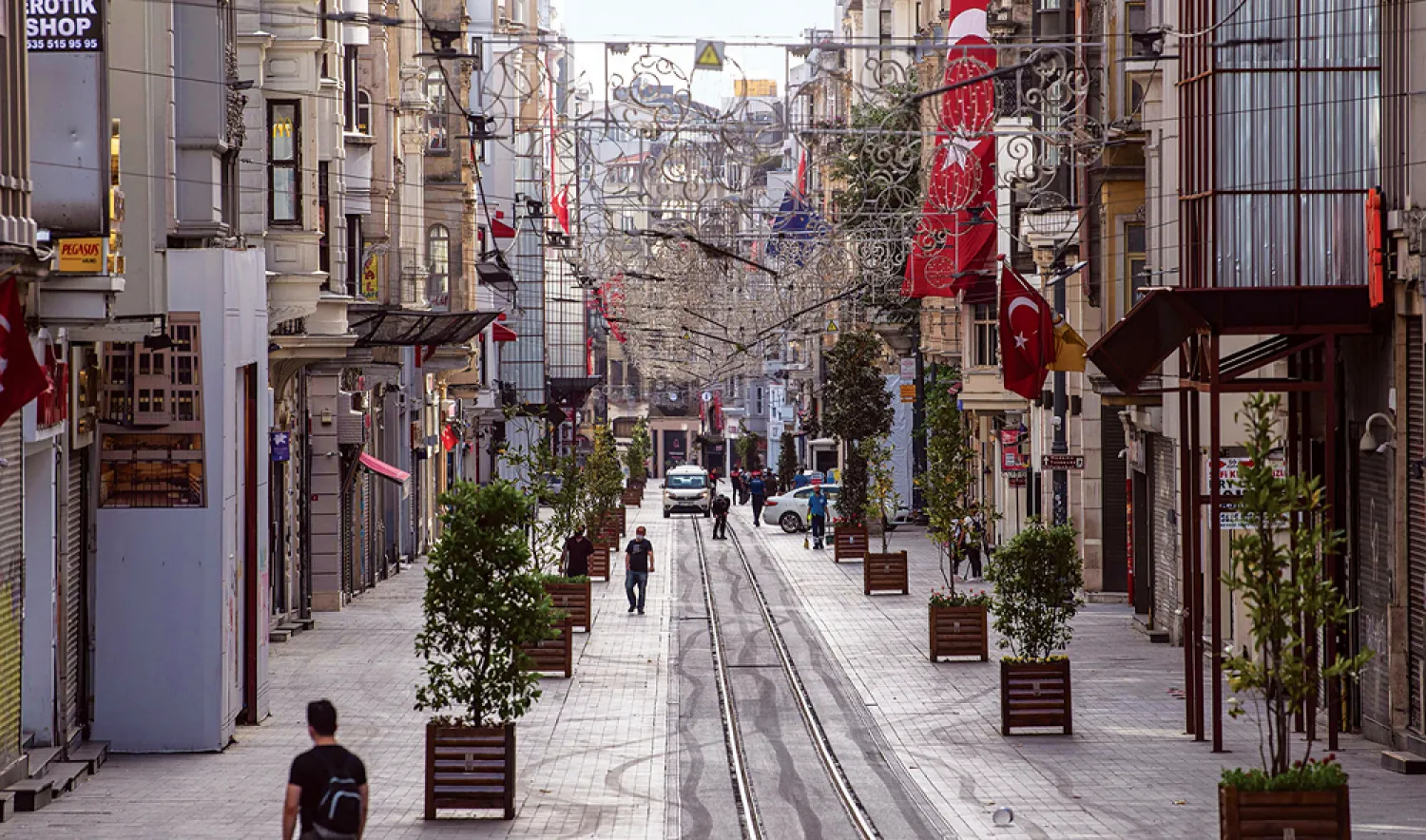 People walk on the deserted Istiklal Street in Istanbul, during a four-day curfew to prevent the spread of the coronavirus epidemic. (AFP)