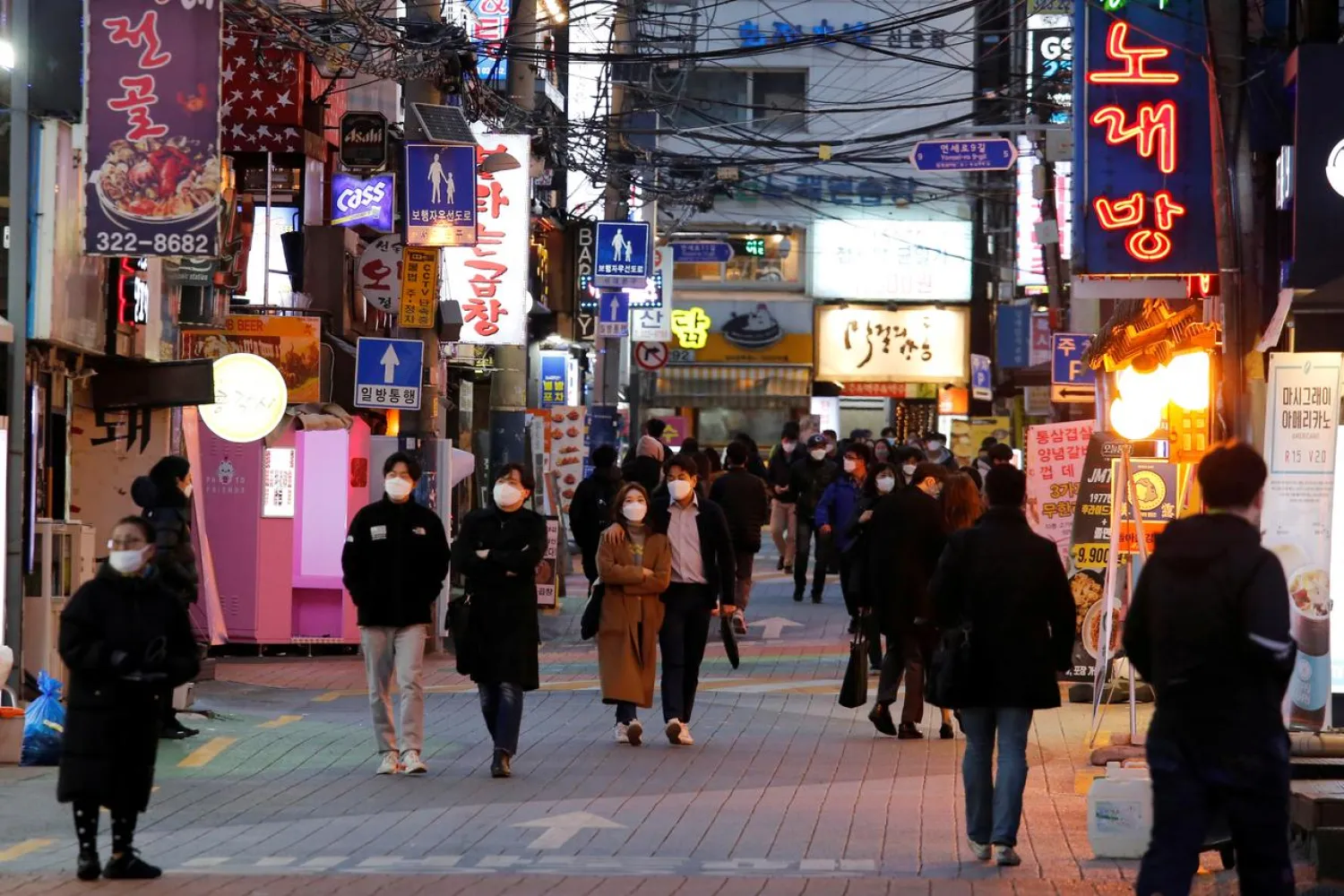 People wearing face masks to protect themselves against contracting the new coronavirus walk on a street in central Seoul, South Korea April 22, 2020. (Reuters)