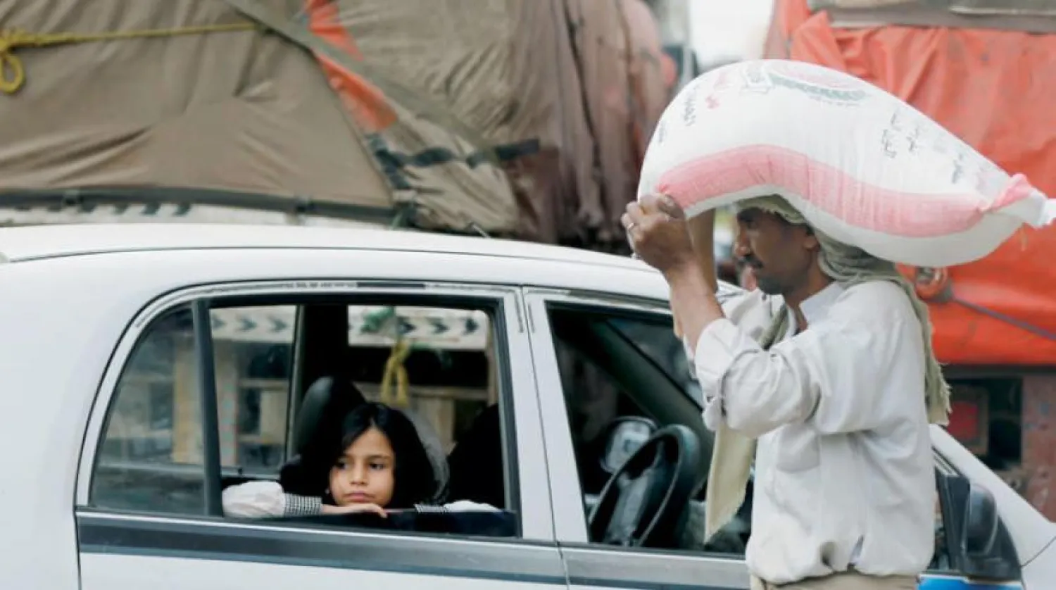 A man carries a bag of flour over his head in a street in Sanaa (Reuters)
