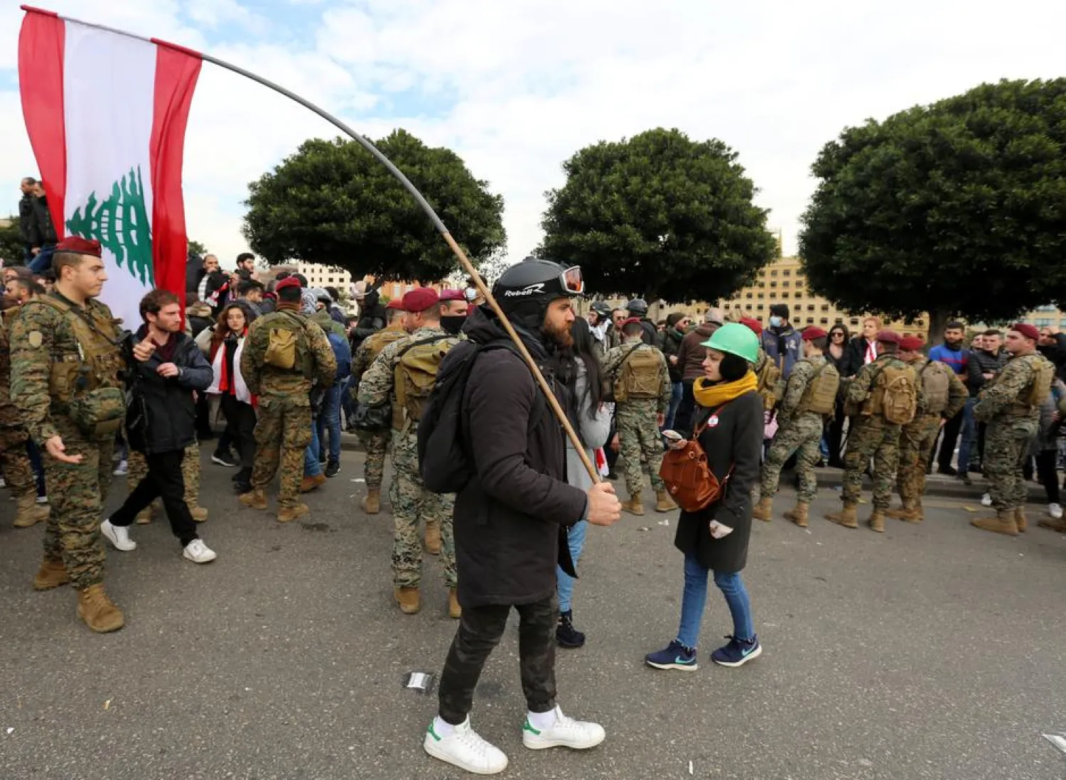 A demonstrator holds the Lebanese flag during a protest seeking to prevent MPs and government officials from reaching the parliament for a vote of confidence, in Beirut, Lebanon February 11, 2020. REUTERS/Aziz Taher