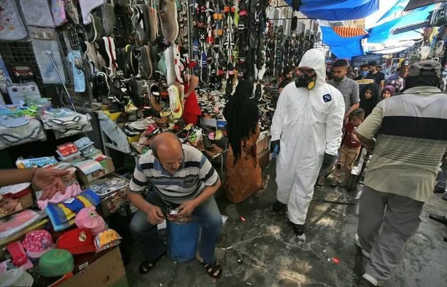 Iraqi civil defense workers disinfect a market in Baghdad. AFP