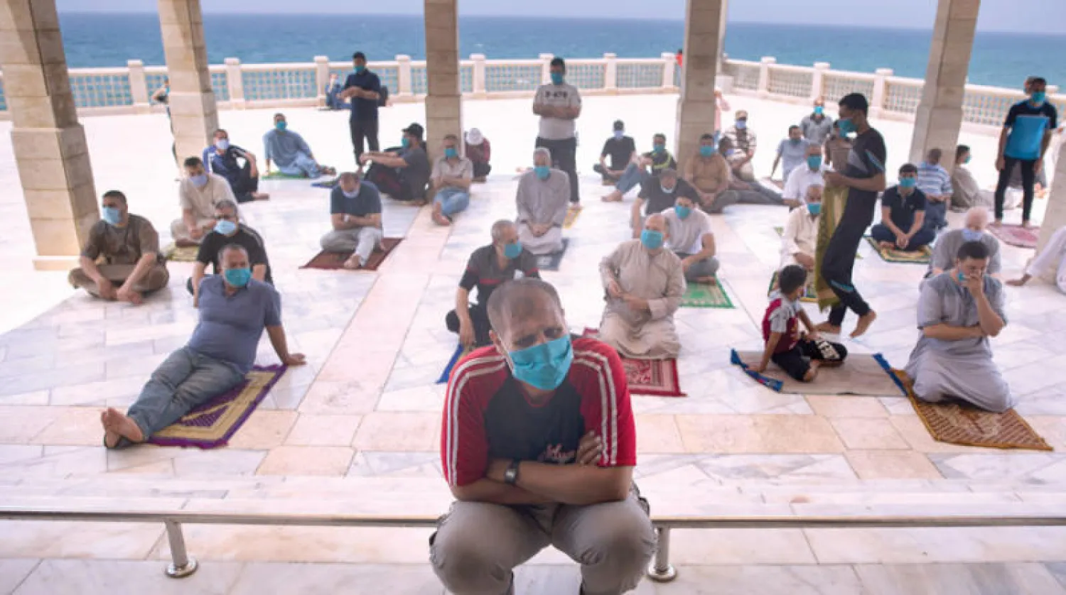 مصلون يرتدون كمامات ويراعون قواعد التباعد قبيل صلاة الجمعة في مسجد بغزة أمس (أ.ب)