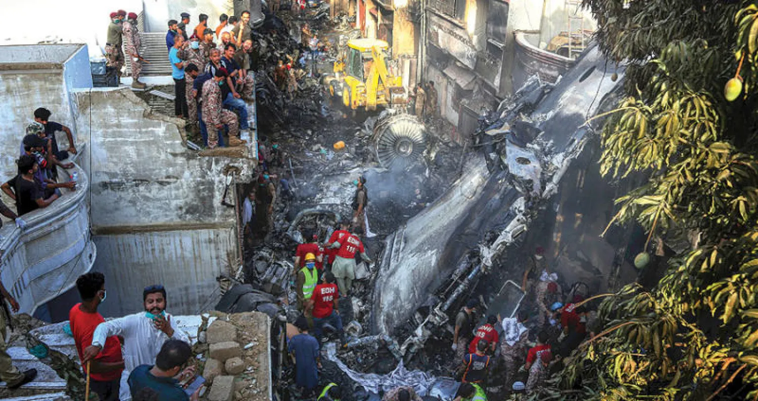 متطوعون يبحثون عن ناجين من حطام الطائرة التي سقطت في كراتشي أمس (أ.ب)