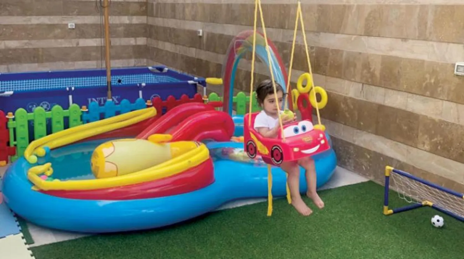 A child enjoys the sun on the roof. (Asharq Al-Awsat)