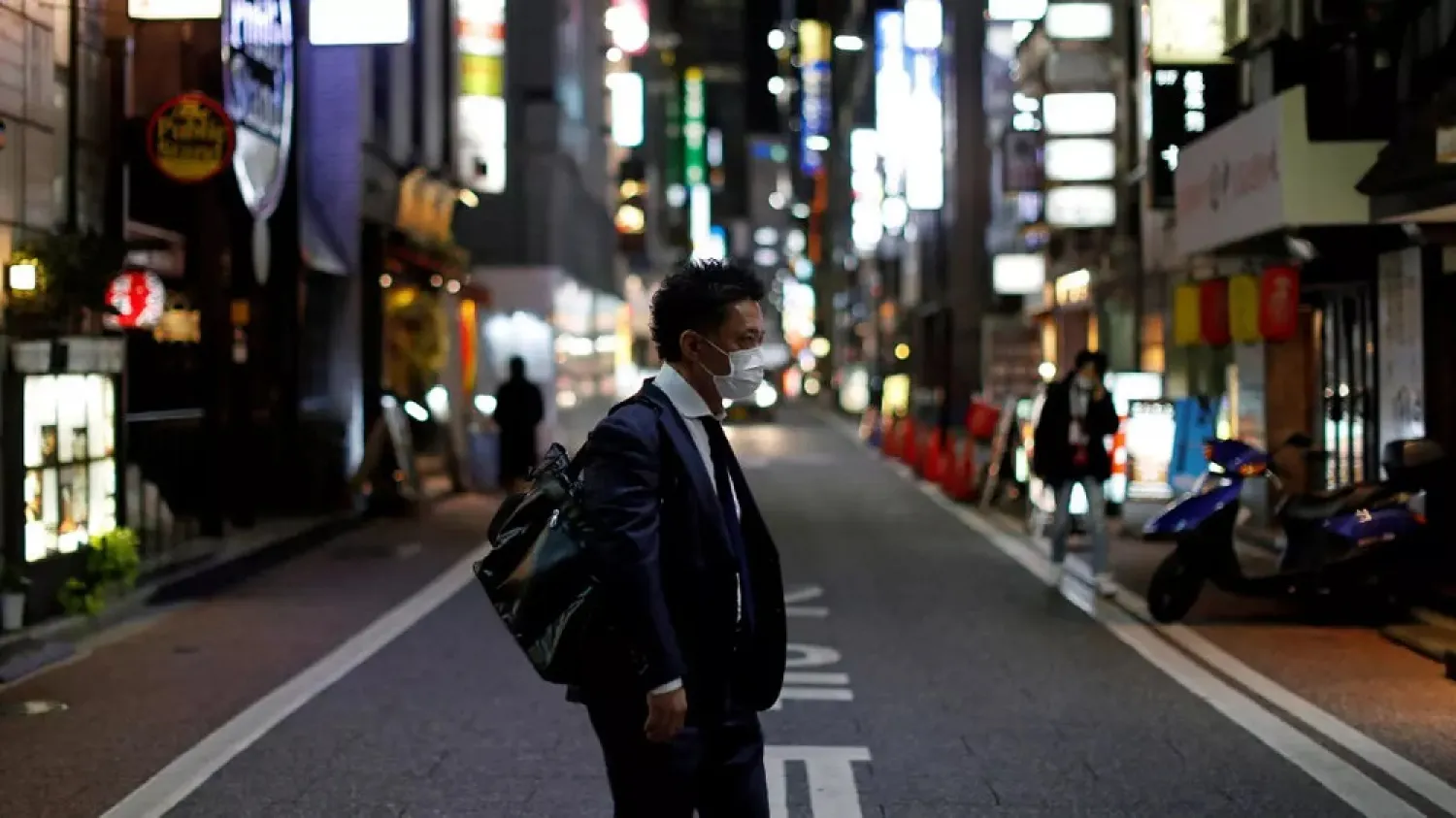 A man wearing a protective face mask, following an outbreak of the coronavirus disease (COVID-19), walks at Ginza shopping and amusement district in Tokyo, Japan April 2, 2020. (Reuters)