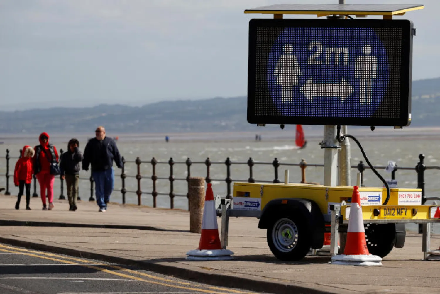 لافتة تدعو للالتزام بقواعد التباعد الاجتماعي في بريطانيا (رويترز)