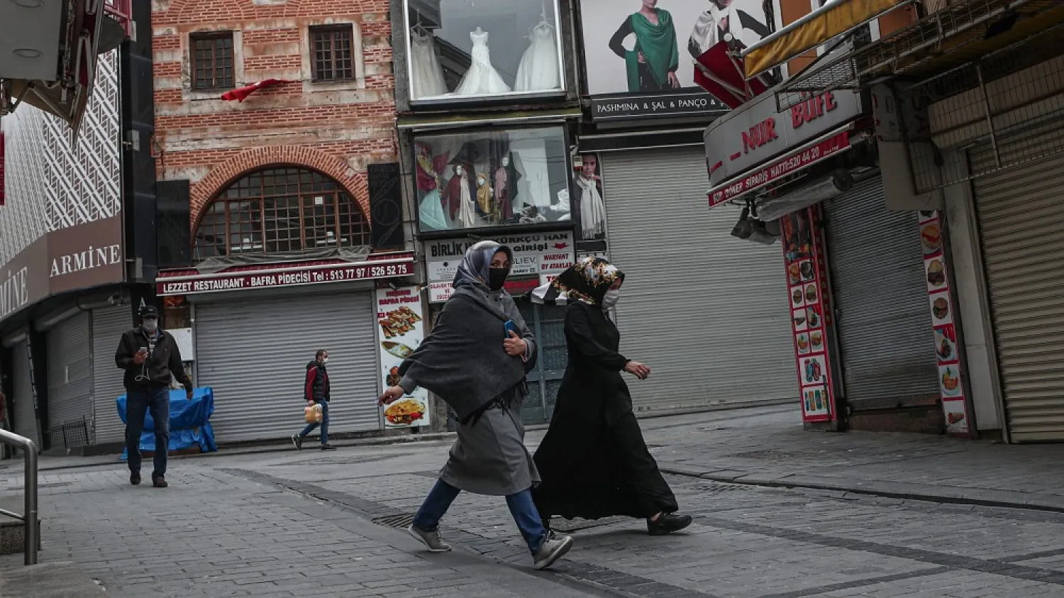 People wearing face masks walk around Mahmut Pasa Bazaar, in Istanbul, Turkey. (EPA)