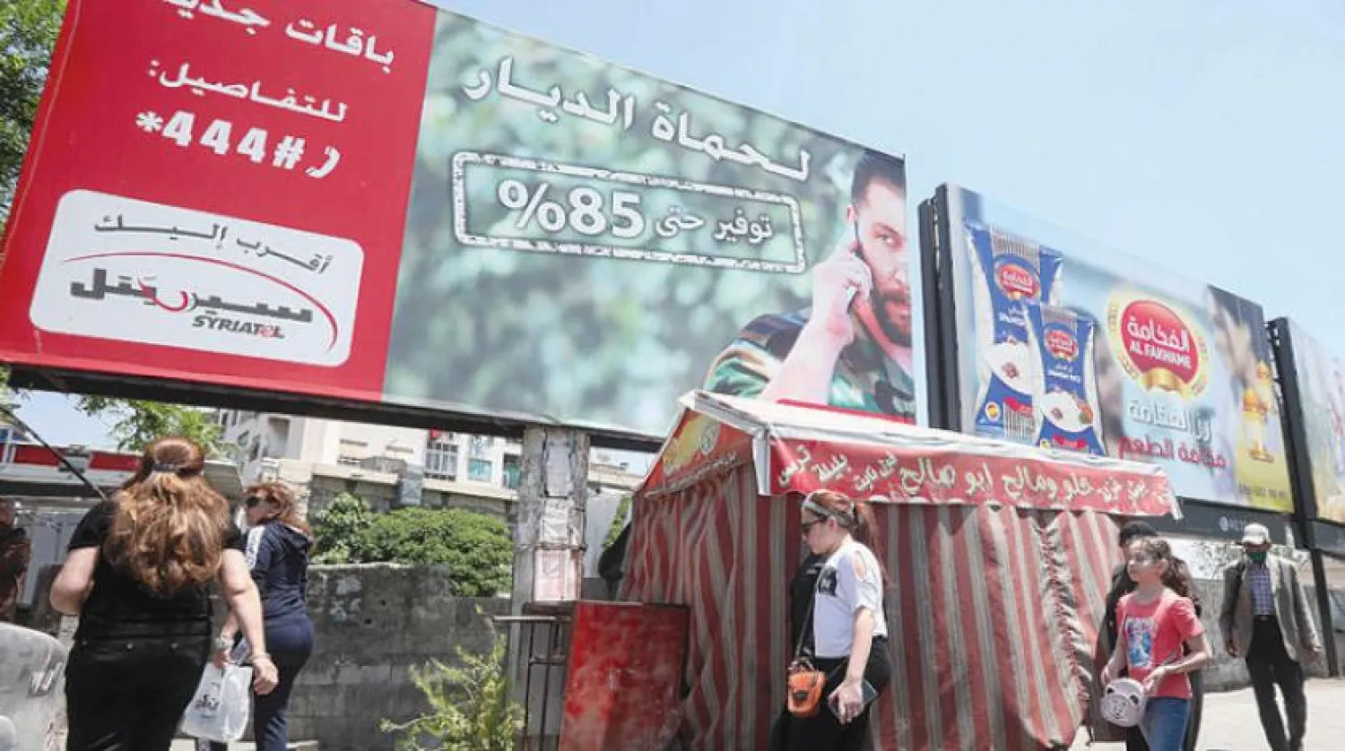 Şam’da Rami Mahluf’un sahibi olduğu Syriatel şirketine ait bir reklam afişi (AFP)