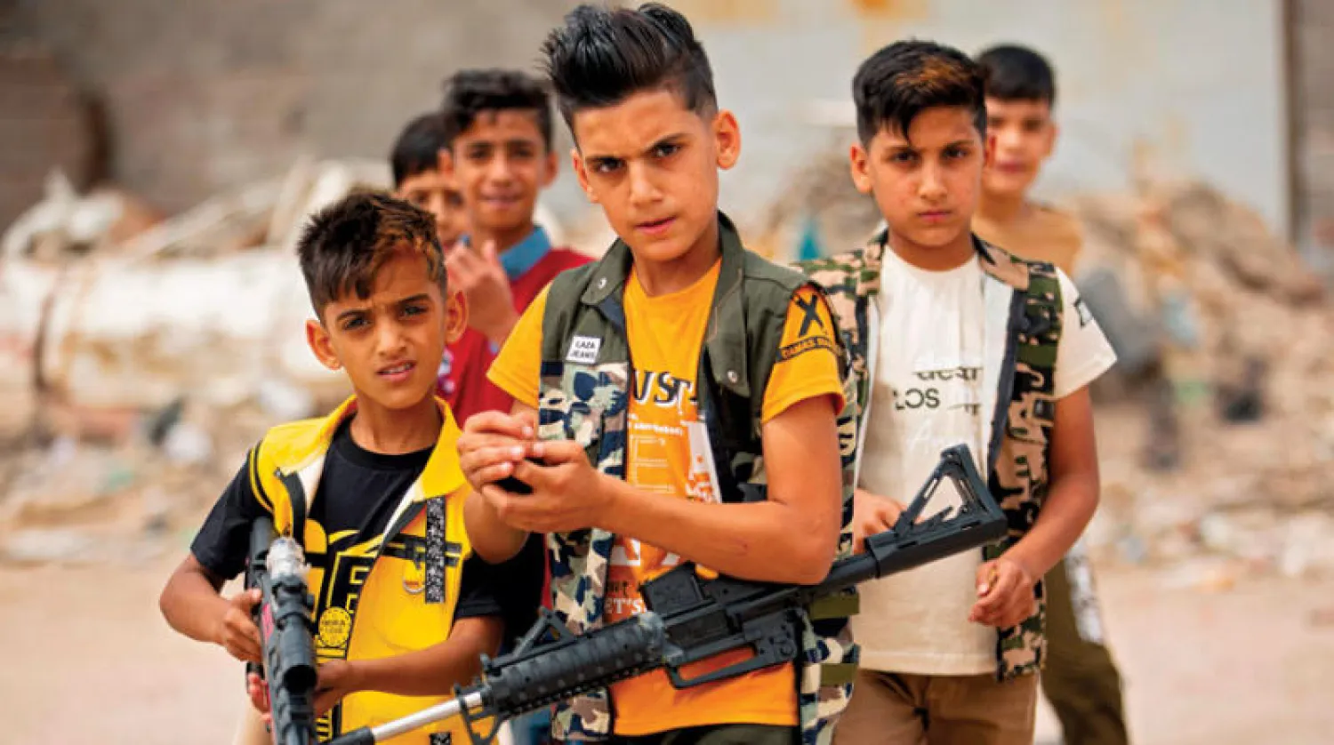 فتية عراقيون يلهون ببنادق بلاستيكية خلال احتفالهم بعيد الفطر في البصرة جنوب العراق أمس (أ.ف.ب)