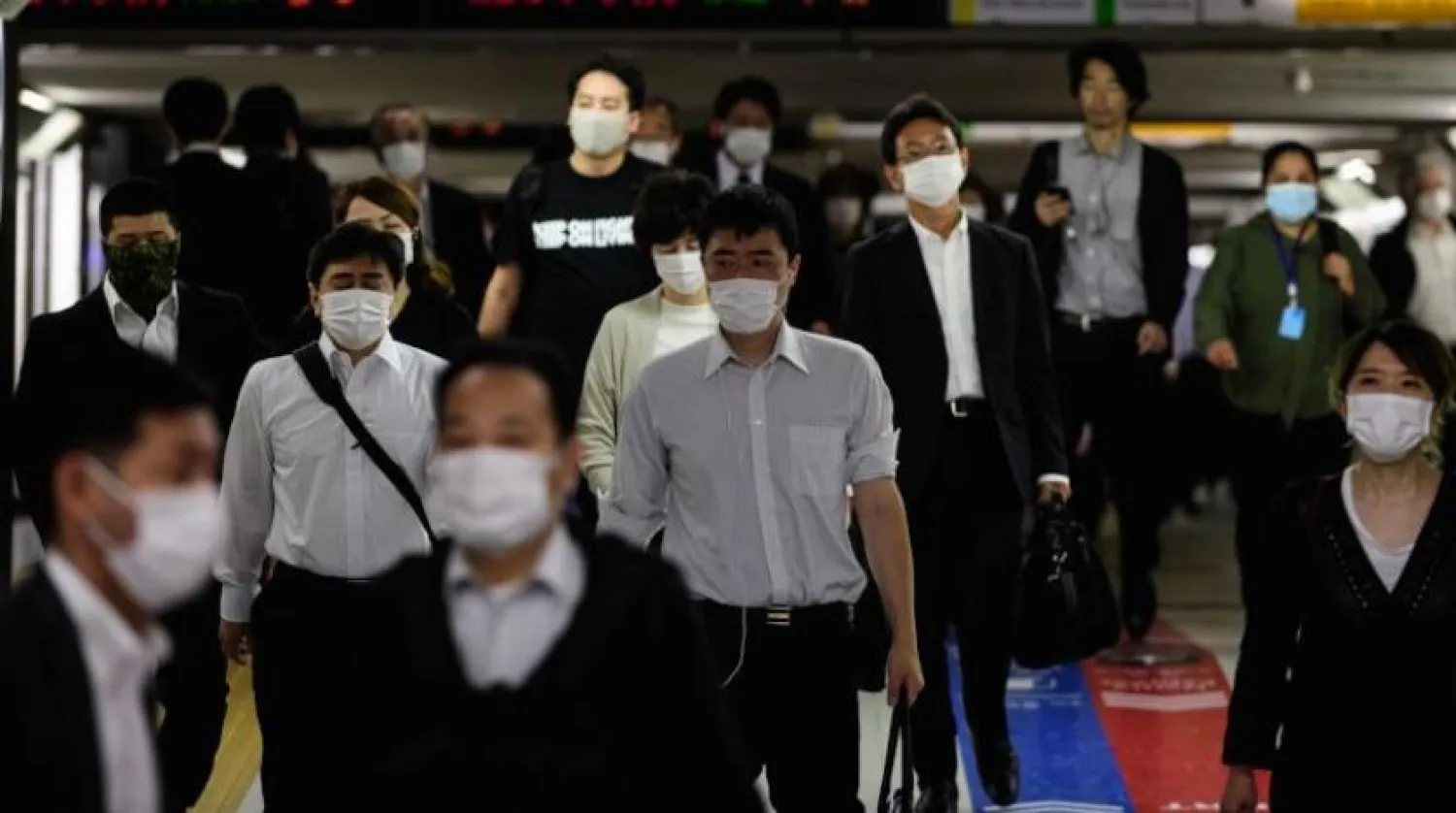 Koronavirüsten korunmak İsteyen Japonlar maske takarken (AFP)