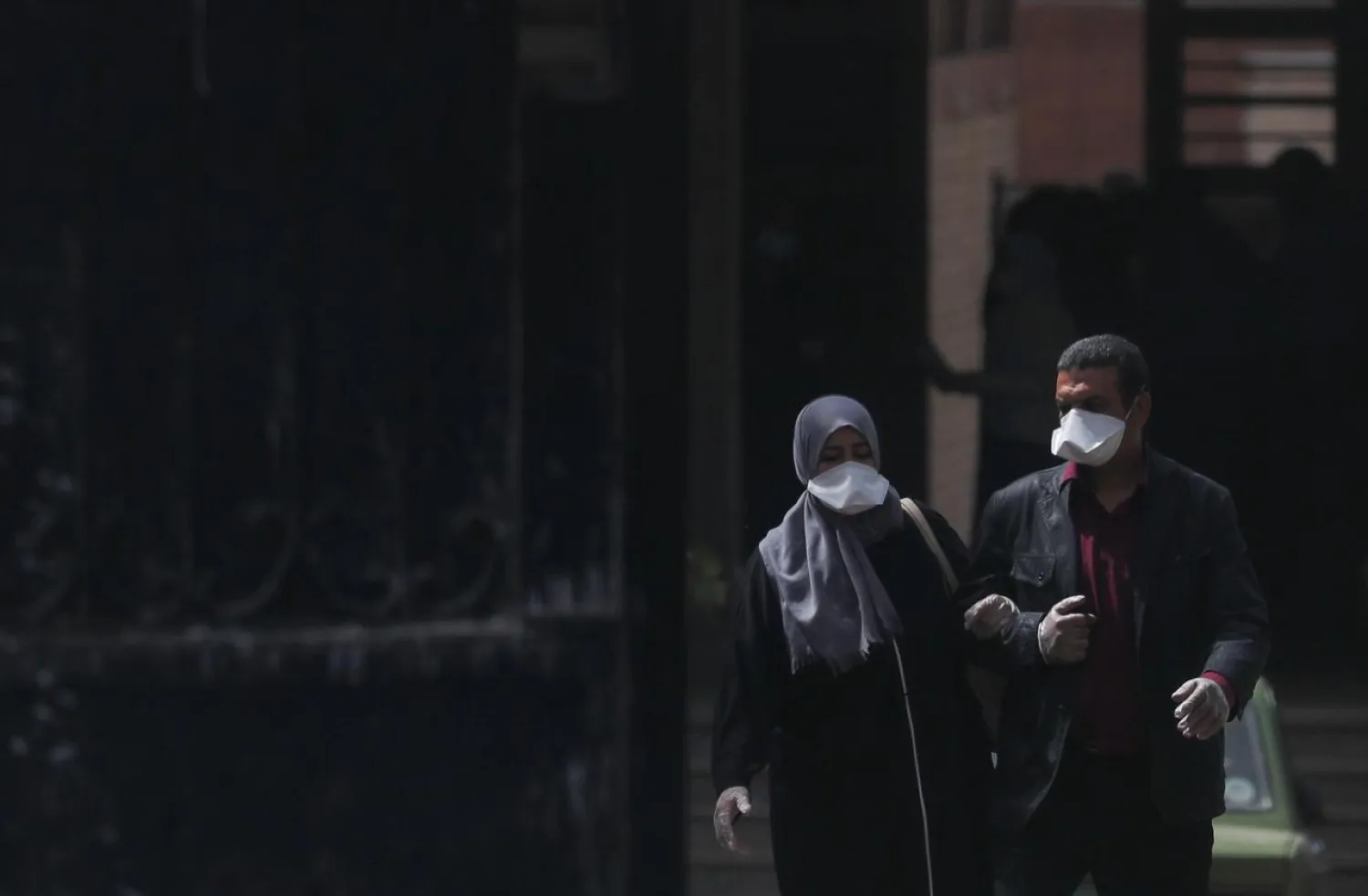 A man and a woman wear protective masks amid concerns over the coronavirus disease (COVID-19) as they walk from the main gate of a hospital in Cairo, Egypt March 31, 2020. REUTERS/Amr Abdallah Dalsh