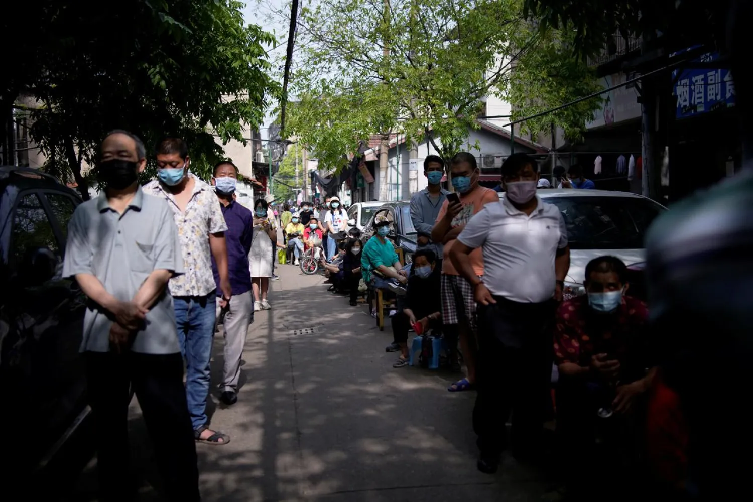 Residents wearing face masks line up for nucleic acid testings in Wuhan, the Chinese city hit hardest by the coronavirus outbreak, May 17, 2020. (Reuters)