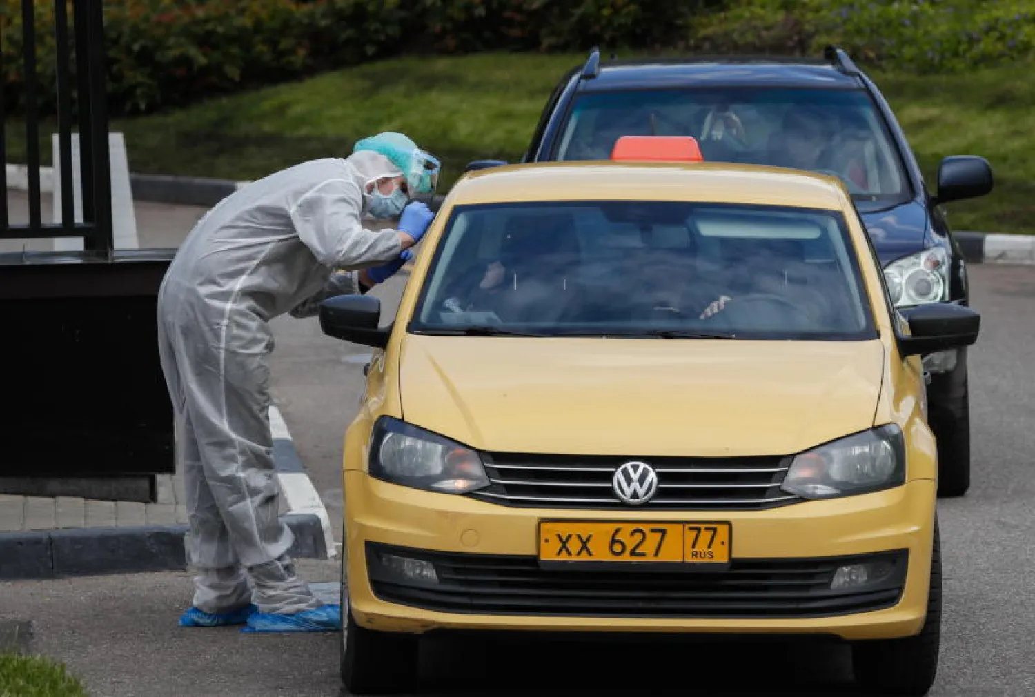 اختصاصي طبي يجري فحص كورونا لركاب سيارة أجرة في موسكو (إ.ب.أ)