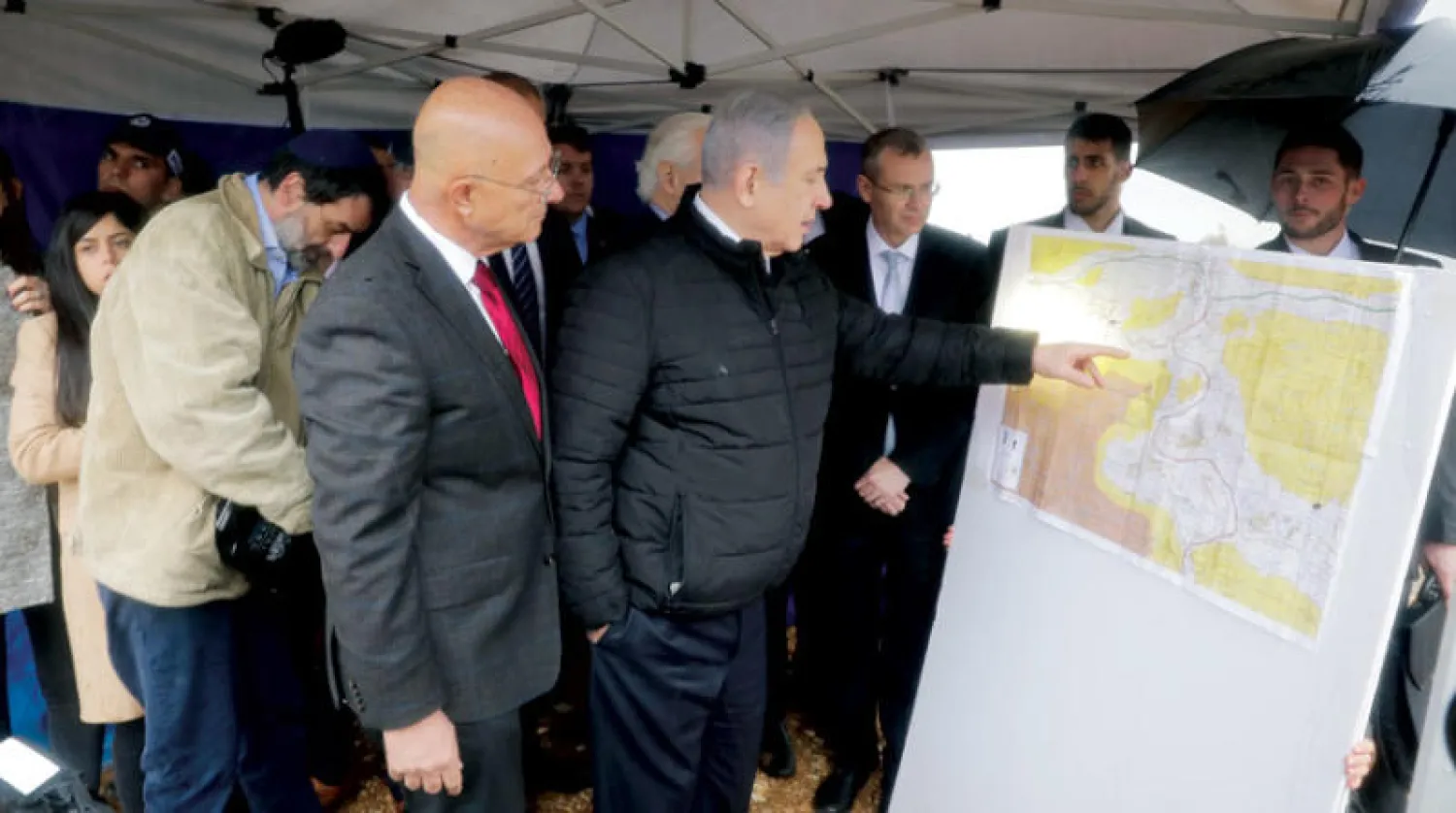 نتنياهو يدقق في خريطة أثناء زيارة إلى مستوطنة في الضفة في فبراير الماضي (أ.ب)