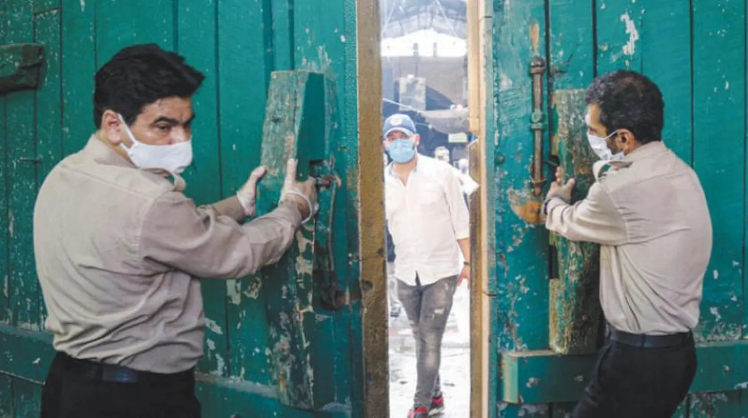 Tahran’ın güneyindeki Rey şehrinde iki aydır kapalı tutulan bir dini mekanın kapılarını açan iki görevli (Mehr)